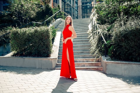 Model in red slit gown on city steps