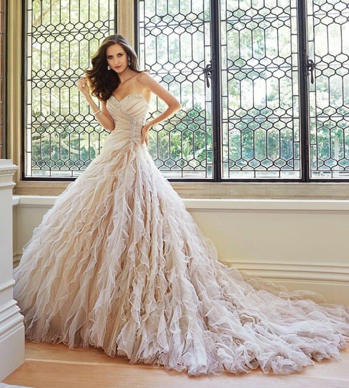 Woman in an elegant blush tulle ball gown wedding dress with sweetheart neckline