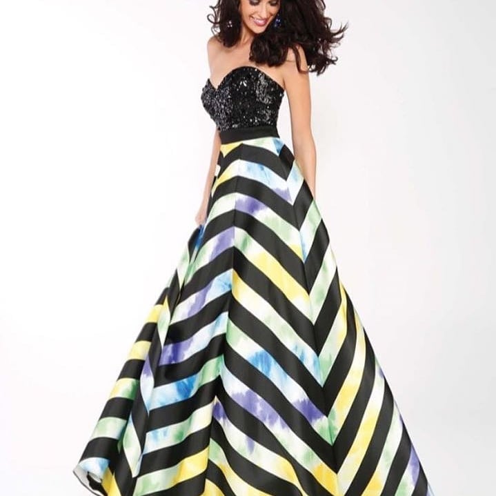 Woman wearing a black sequined strapless top with colorful chevron striped ball gown skirt