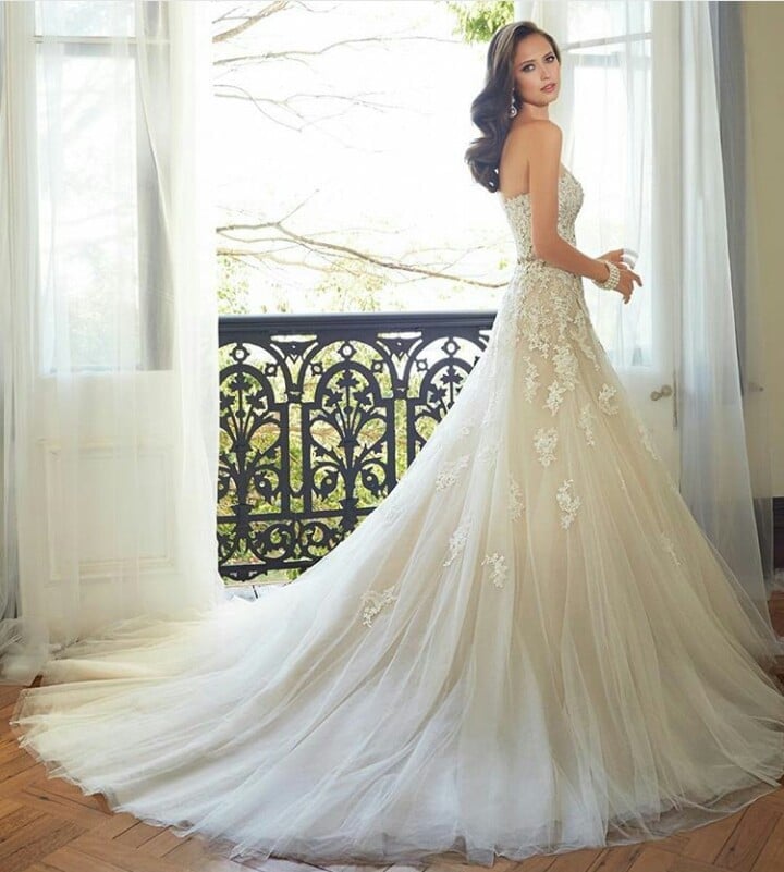 Woman in white wedding gown with floral beading and flowing train